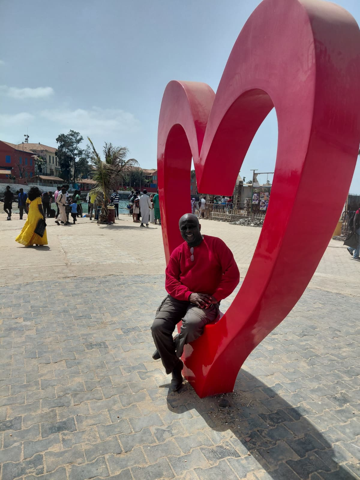 Dr. Ndi at the heart monument with Gorée Island village behind